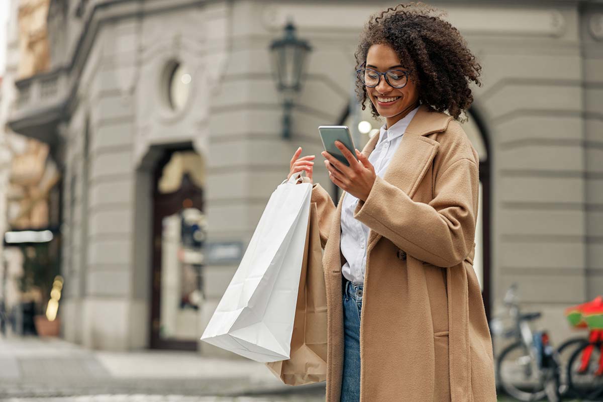 (Woman on phone carrying shopping bags)