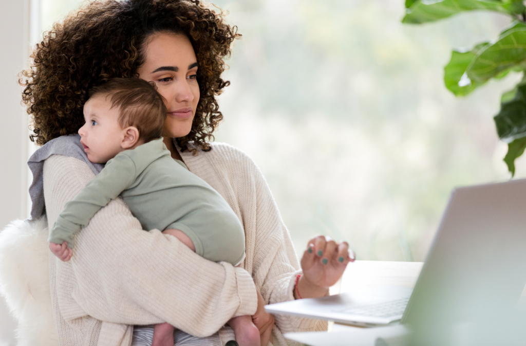 Women holding baby using laptop